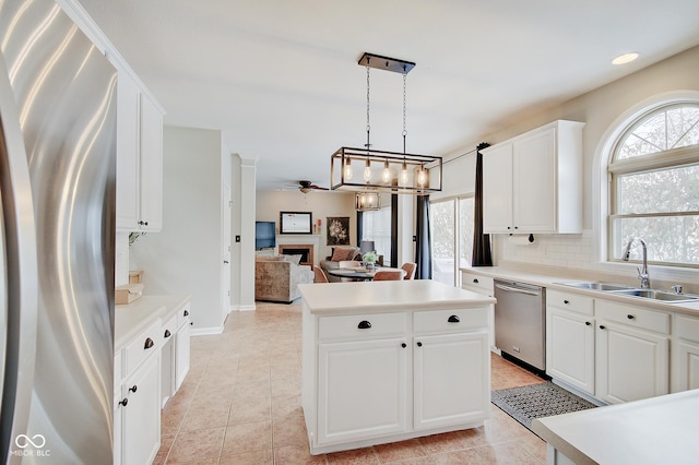 kitchen featuring decorative light fixtures, white cabinetry, stainless steel appliances, tasteful backsplash, and plenty of natural light