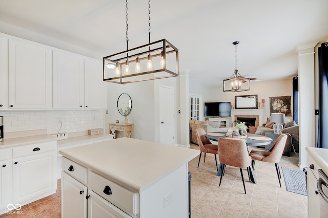 kitchen with decorative backsplash, white cabinetry, pendant lighting, and a kitchen island