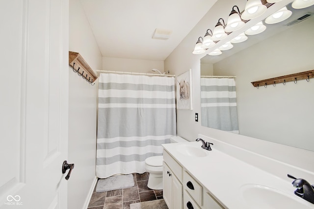 bathroom featuring vanity, toilet, and walk in shower