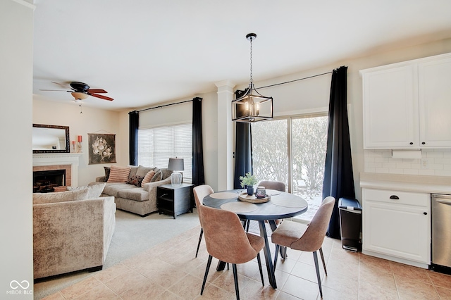 tiled dining space featuring ceiling fan and a tile fireplace