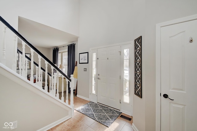 entryway featuring a high ceiling and light tile patterned floors