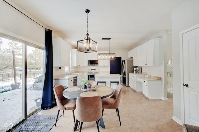 dining area with sink, light tile patterned flooring, and a notable chandelier