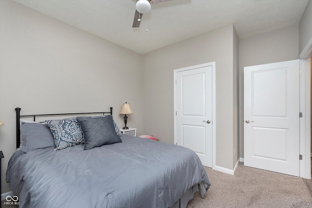 bedroom with a textured ceiling, ceiling fan, and light colored carpet