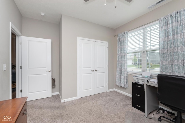 carpeted home office featuring ceiling fan