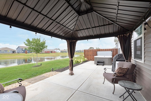 view of patio / terrace featuring a water view, a gazebo, and a hot tub