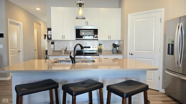 kitchen with white cabinetry, a center island with sink, and stainless steel appliances