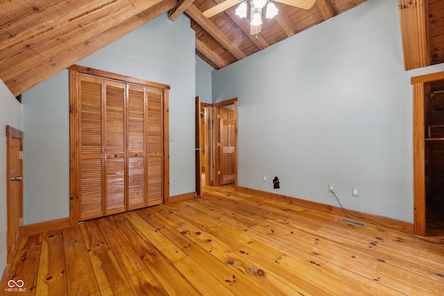 unfurnished bedroom with ceiling fan, beamed ceiling, light hardwood / wood-style flooring, a closet, and wooden ceiling