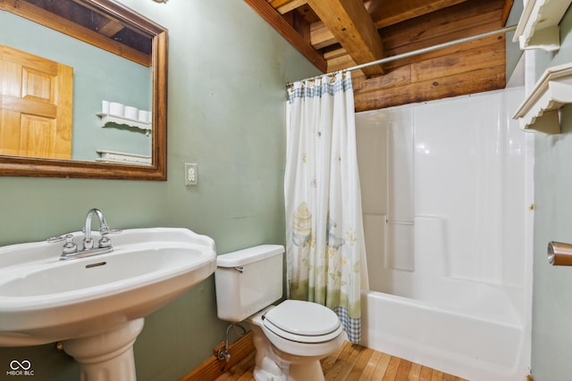 full bathroom with toilet, hardwood / wood-style floors, beam ceiling, sink, and shower / bath combination with curtain