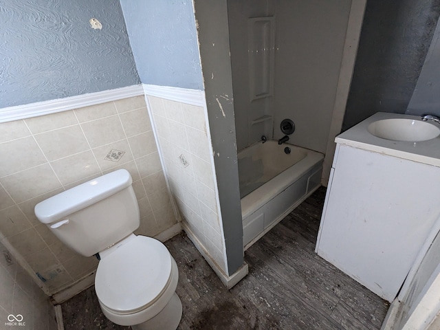 full bathroom with toilet, shower / tub combination, tile walls, wood-type flooring, and vanity