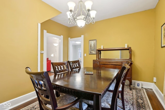 dining area with an inviting chandelier and hardwood / wood-style flooring