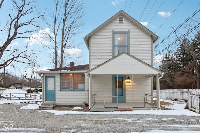 snow covered house featuring covered porch