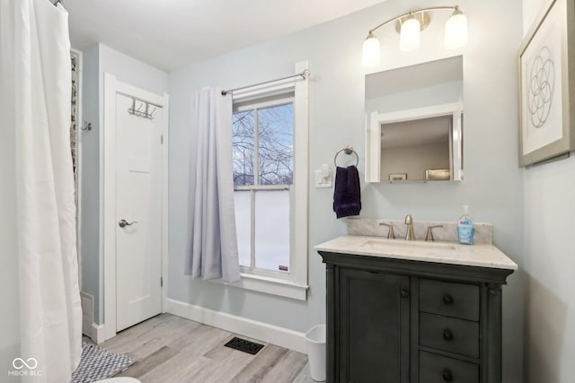 bathroom with plenty of natural light, hardwood / wood-style floors, vanity, and shower / bath combination with curtain