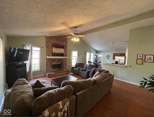 living room with a textured ceiling, a brick fireplace, a wealth of natural light, and lofted ceiling