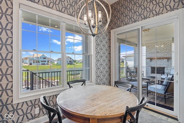 dining room with wallpapered walls, a wealth of natural light, and a notable chandelier