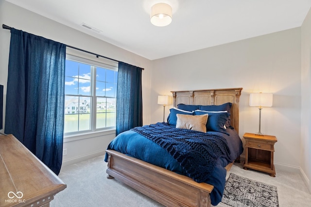 bedroom featuring visible vents, light carpet, and baseboards