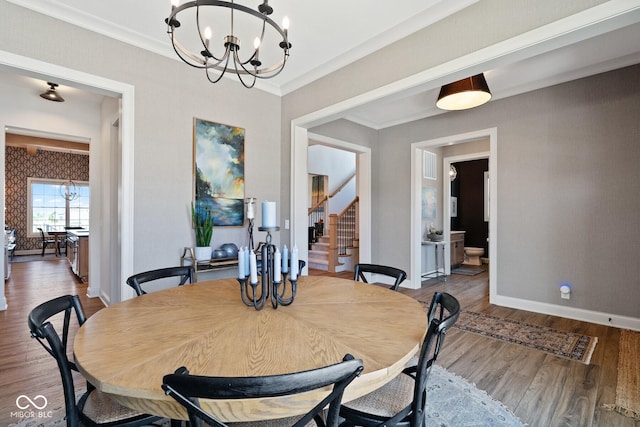 dining room with stairway, an inviting chandelier, ornamental molding, wood finished floors, and baseboards