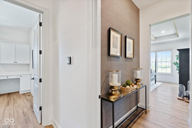 hall featuring light wood-style flooring and baseboards