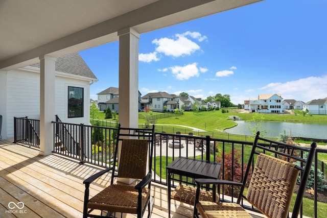 wooden terrace with a residential view and a water view