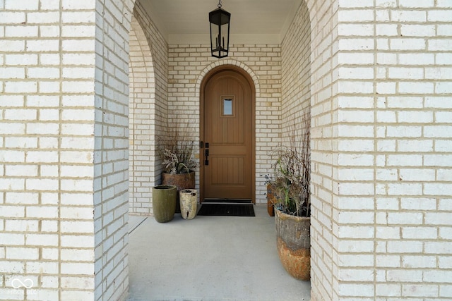 entrance to property featuring brick siding