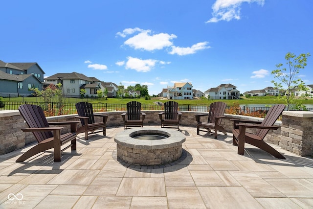 view of patio / terrace with a residential view, fence, and a fire pit