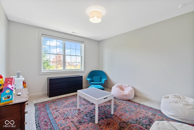 sitting room with baseboards, visible vents, and carpet flooring