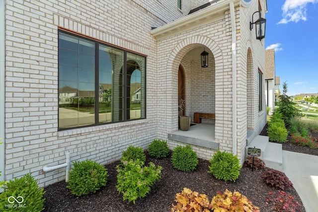 view of exterior entry with brick siding