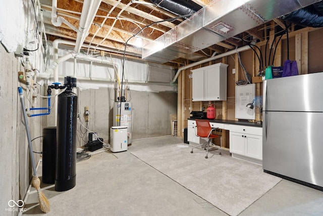 unfinished below grade area featuring freestanding refrigerator and gas water heater