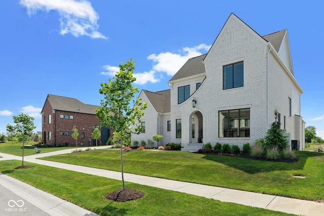 view of front of property featuring a front yard and brick siding