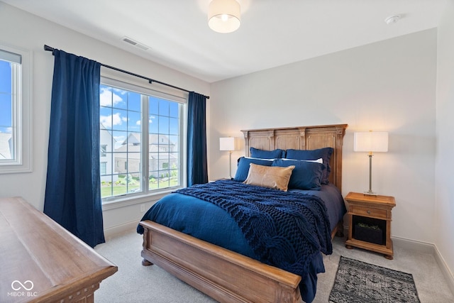 bedroom with light colored carpet, visible vents, and baseboards