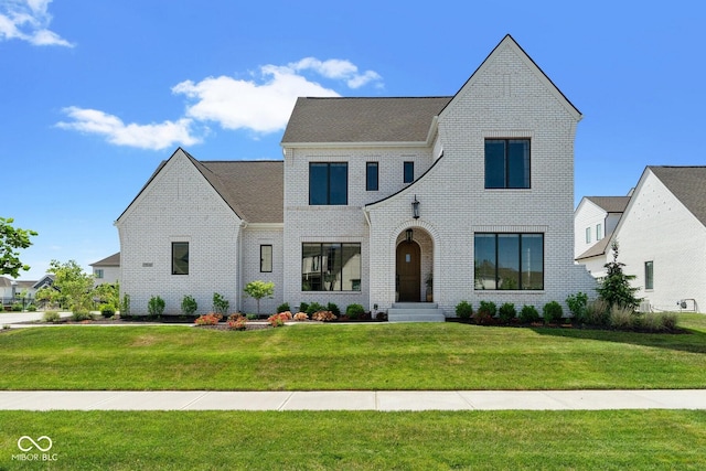 view of front facade featuring brick siding and a front lawn