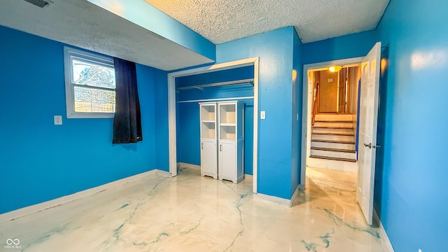 unfurnished bedroom with a closet and a textured ceiling