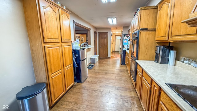 kitchen with light hardwood / wood-style flooring and black appliances