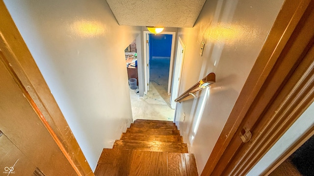 stairway with a textured ceiling