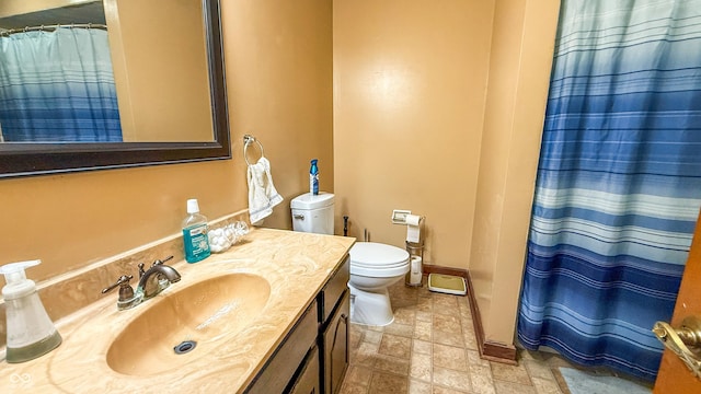 bathroom featuring toilet, vanity, and a shower with curtain