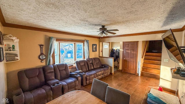 living room featuring ceiling fan, a textured ceiling, ornamental molding, and hardwood / wood-style floors