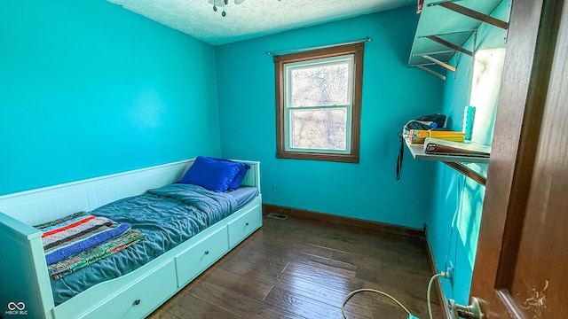 bedroom with dark hardwood / wood-style flooring and a textured ceiling