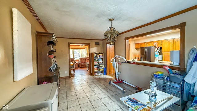 miscellaneous room with a textured ceiling, an inviting chandelier, light tile patterned floors, and ornamental molding