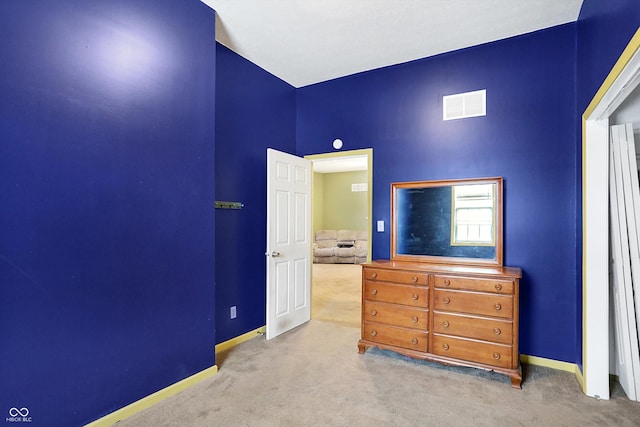 bedroom with light carpet and a high ceiling