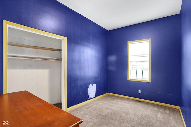 unfurnished bedroom featuring carpet floors and a closet