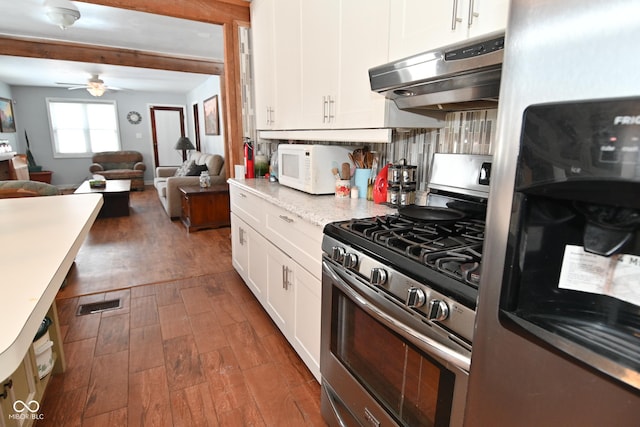 kitchen with white cabinetry, stainless steel gas range oven, ceiling fan, fridge, and dark hardwood / wood-style flooring