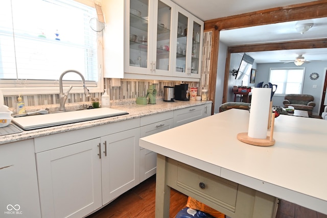 kitchen featuring white cabinetry, dark hardwood / wood-style flooring, tasteful backsplash, sink, and ceiling fan