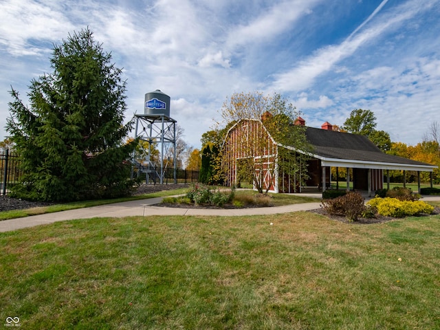 view of property's community with a yard, a barn, and fence