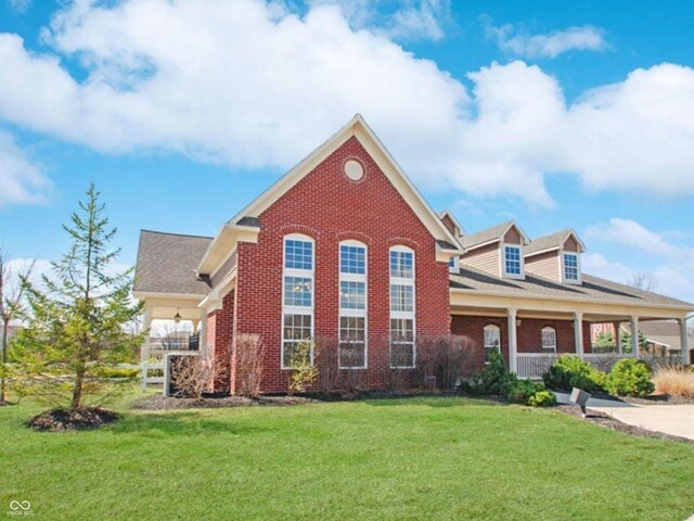 view of front of home featuring brick siding, a porch, and a front yard