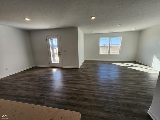 spare room featuring dark hardwood / wood-style floors and a textured ceiling