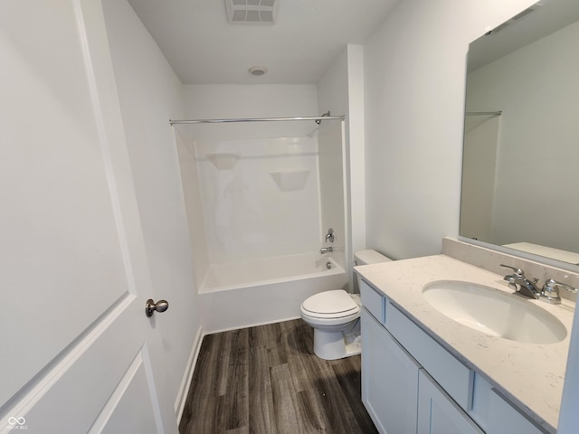 bathroom with visible vents, toilet, wood finished floors, vanity, and shower / bathing tub combination