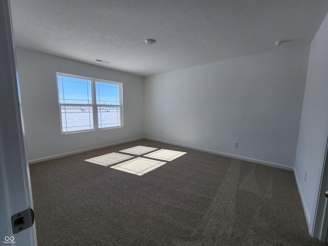 carpeted empty room with visible vents, baseboards, and a textured ceiling