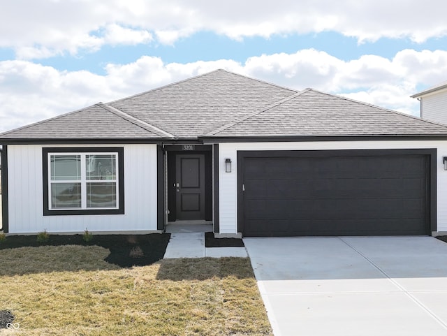 view of front of property with a garage, a front lawn, concrete driveway, and roof with shingles