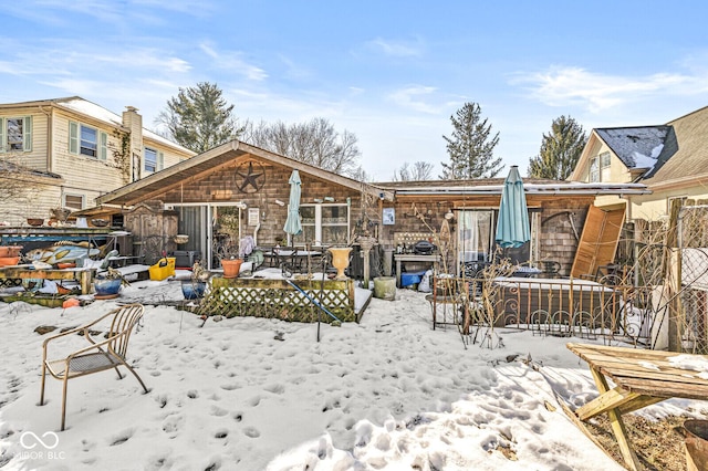 view of snow covered back of property