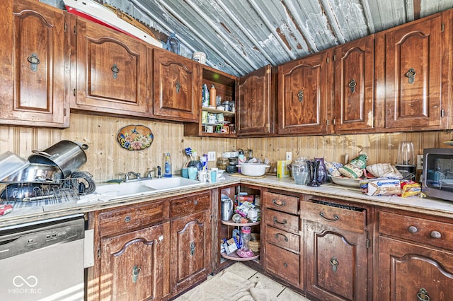 kitchen featuring sink, wooden walls, and stainless steel dishwasher