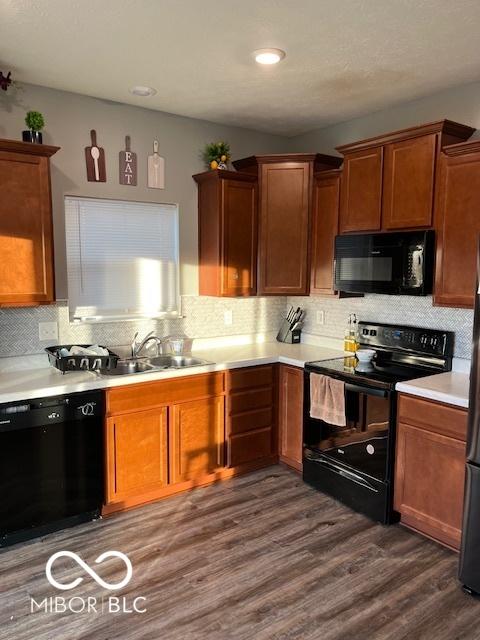 kitchen featuring sink, backsplash, black appliances, and dark hardwood / wood-style flooring